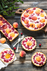Rustic open pie with peach and raspberry, french galette . Peach tart. Raspberry tart. Tartalette with cream. Variety of bakery.