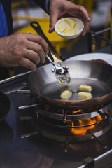 Chef doing flambe to food in pan with alcohol in big flame