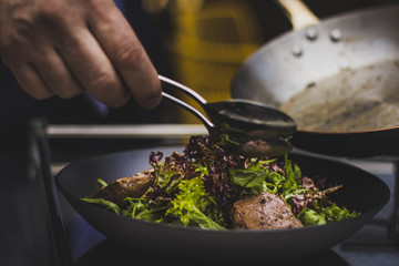 Chef doing flambe to food in pan with alcohol in big flame