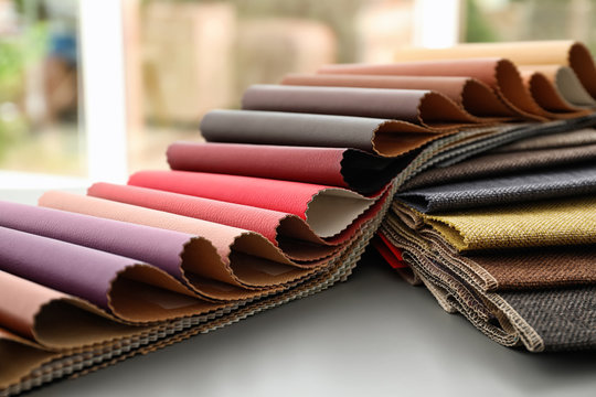 Fabric and leather samples of different colors for interior design on table