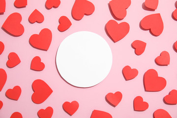 Small paper hearts and blank card on color background