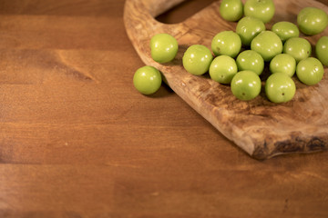 Green Plums on Wood