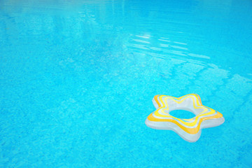 Inflatable colorful ring floating on water in swimming pool