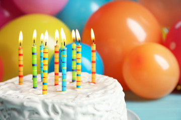 Delicious birthday cake with burning candles, closeup