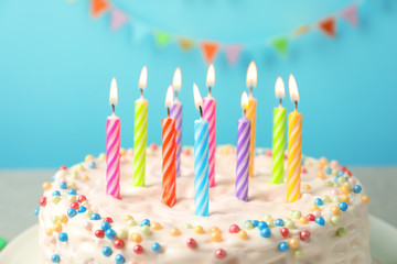 Delicious birthday cake with burning candles, closeup