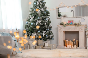 Stylish living room interior with decorated Christmas tree and blurred lights in foreground