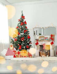 Stylish living room interior with decorated Christmas tree and blurred lights in foreground