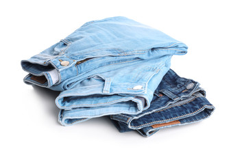 Stack of stylish jeans on white background