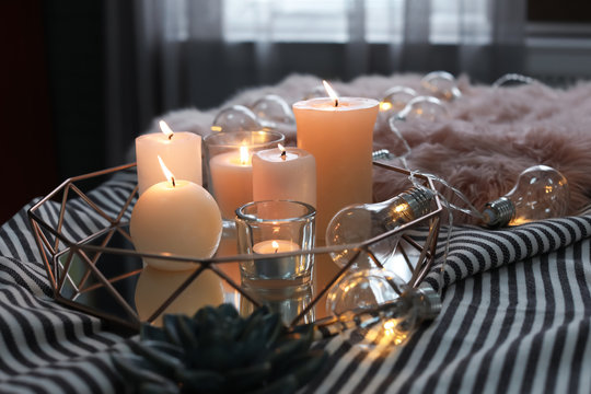 Tray with burning candles on striped fabric