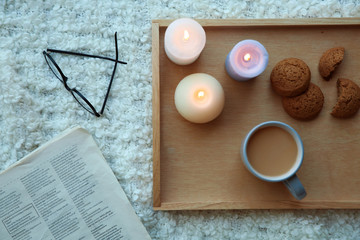 Flat lay composition with burning candles on soft fabric