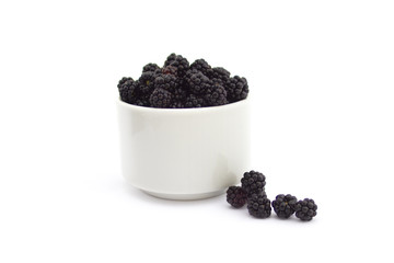Fototapeta na wymiar Withe cup with blackberries on white