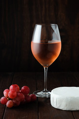 Still life with pink wine, brie cheese and grapes