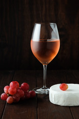 Still life with pink wine, brie cheese and grapes