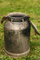 Obraz premium The iron cans on a background of green grass, village concept