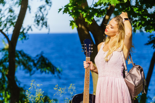 Girl with guitar outdoor on nature