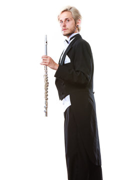 Male flutist wearing tailcoat holds flute