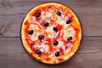 Delicious traditional pizza with ham and black olives on wood, flat lay. Italian food, restaurant menu photo