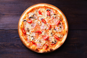 Delicious traditional pizza with ham and mushrooms on wood, close up. Italian food, restaurant menu photo