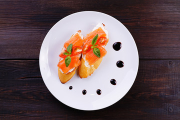 Italian antipasto- bruschetta with smoked salmon, appetizing popular mediterranean meals. Buffet, restaurant menu, banquet snack