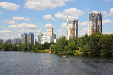 Naklejka premium Russia, Moscow, modern architecture - new towers in the Strogino area on a summer day against the blue sky with white clouds, view from the Moscow river
