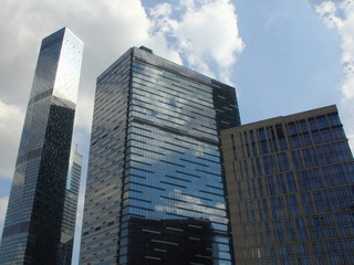 Naklejka premium Bottom view of the glass skyscrapers in Moscow - business center Moscow city in the afternoon against the blue sky with clouds