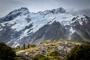 Fototapeta na wymiar Two climbers head up the track towards the mountain range for a weekend adventure
