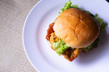 Chicken Hamburger on the white plate with black background. Selective Focus.Visible Noise,Image...