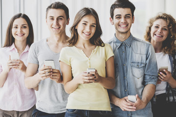 Group of Young Positive Friends Holding Phones