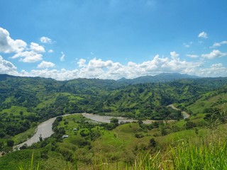 Fototapeta na wymiar Imponente vista del Río Cauca, su valle y las montañas verdes de la Cordillera Occidental de los Andes, que cruza a Colombia