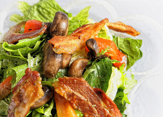 Green salad in a bowl, with spinach and bacon.