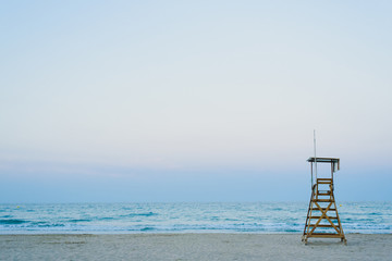 Lifeguard watchtower on the beach at sunset.