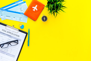 Prepare to trip. Do visa. Airplane tickets near passport cover with airplane silhouette, visa application form, compas on yellow background top view copy space © 9dreamstudio