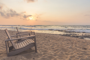 Fototapeta na wymiar Empty beach chairs on the coast at sunset