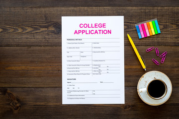 Apply college. Empty college application form near coffee cup and stationery on dark wooden background top view copy space