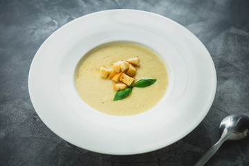Homemade pea soup with grilled bread in a bowl and spoon. Restaurant food