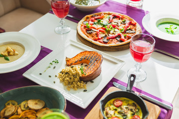 Table in cafe with vegetarian dishes - pizza, salads, pumpkin and fresh fruit drinks.