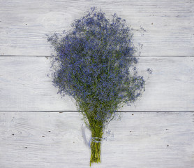 background. defocusing. Field flowers of blue color on a light wooden table