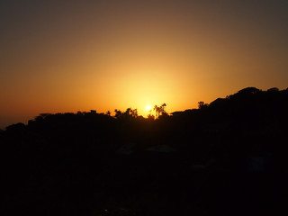Sunset past tropical mountain silhouette