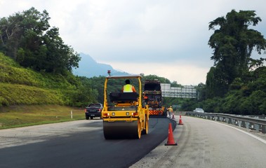 Fototapeta na wymiar Terengganu, Malaysia - July 3, 2018: Asphalt Roller aligns new asphalt on highway road at East Coast Expressway or Lebuhraya Pantai Timur (LPT) in Terengganu.