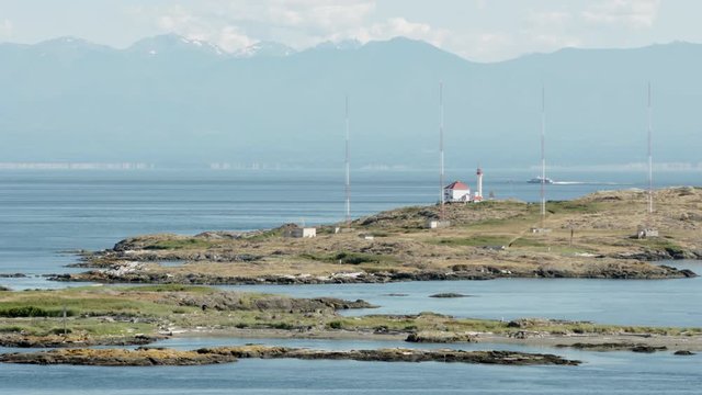Trial Islands, Victoria 4K UHD. The lighthouse on the Trial Islands, near Victoria on Vancouver Island. The Olympic Mountain range, in Washington State, is in the background. 4K. UHD.
