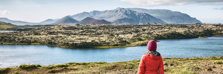 Iceland hiking travel adventure - woman tourist walking in mountain landscape looking at amazing...