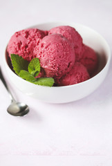 Raspberry ice cream in white bowl