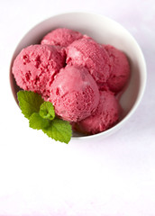 Raspberry ice cream in white bowl