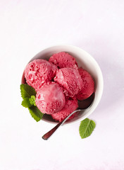 Raspberry ice cream in white bowl