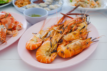 grilled shrimp on dish with spicy seafood saucebrown wooden table background..
