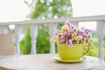 Cute dry flower in green cup flower pot decorated on table with copy space for text or image.