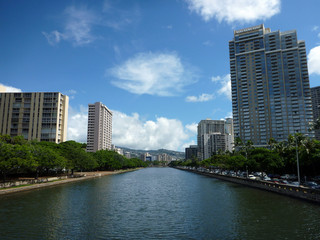 Fototapeta na wymiar Ala Wai Canal, hotels, Condos, and trees on a nice day in Waikiki on Oahu