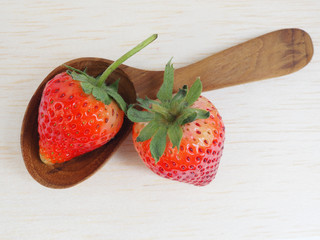 Fresh strawberry with spoon on wooden background, healthy food and diet.