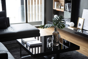 cozy black glass coffee table setting with artificial plants compose with white book - Powered by Adobe