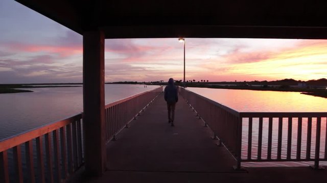 Walking out onto a small fishing pier in Lake Okeechobee at dusk.